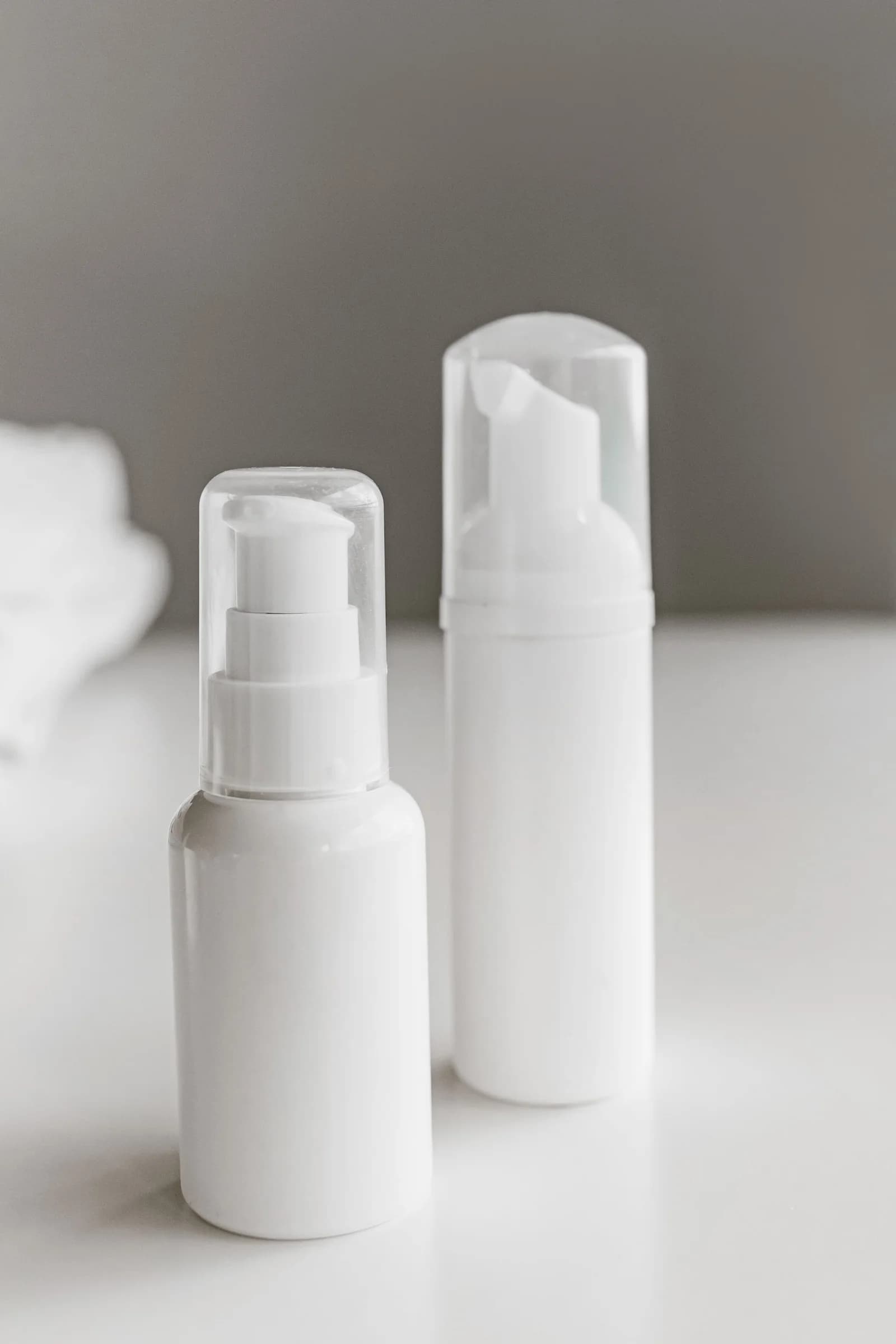 Two unbranded white pump bottles prepared for private label packaging