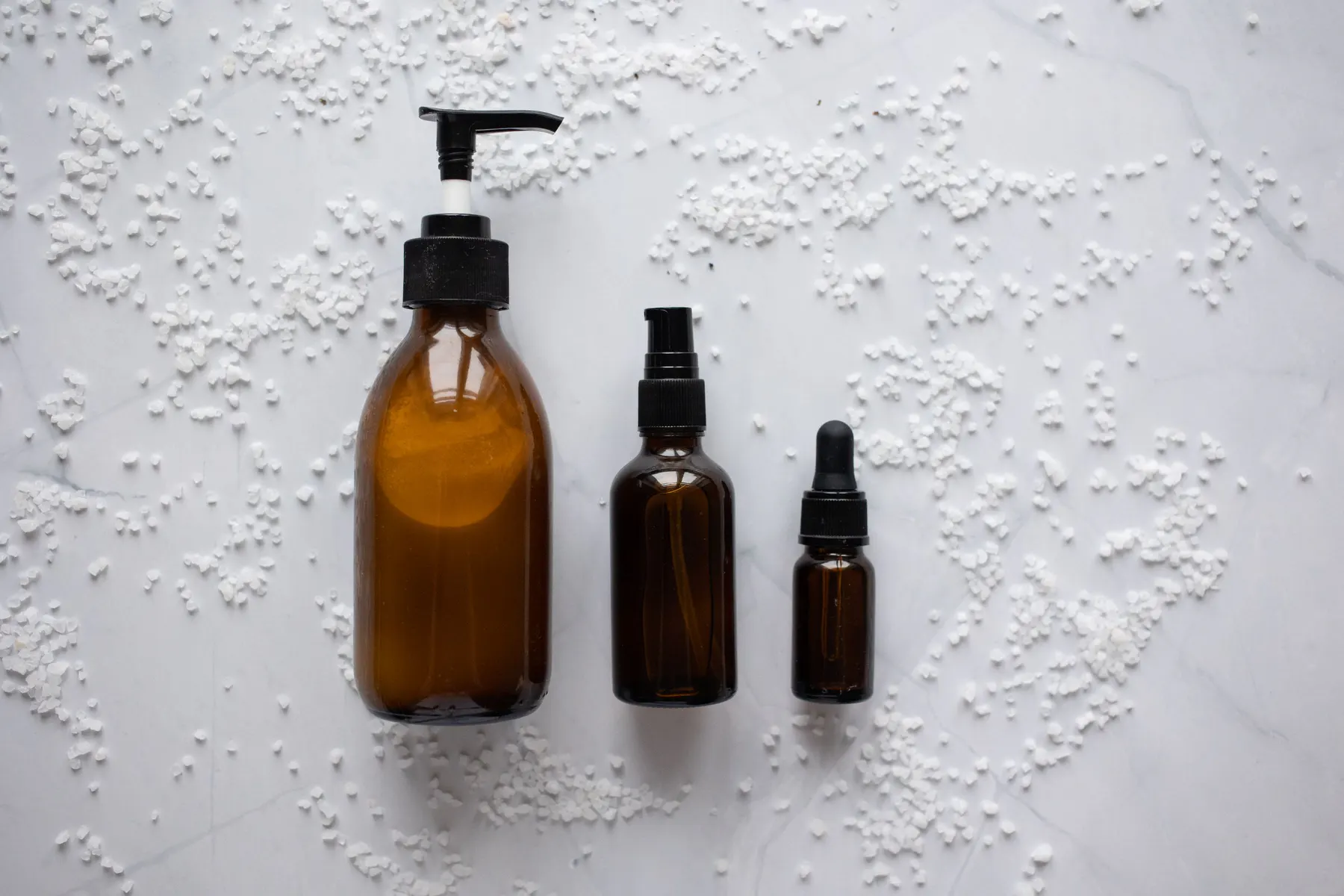 Cosmetic pump, dropper and jar packaging arranged on a work surface