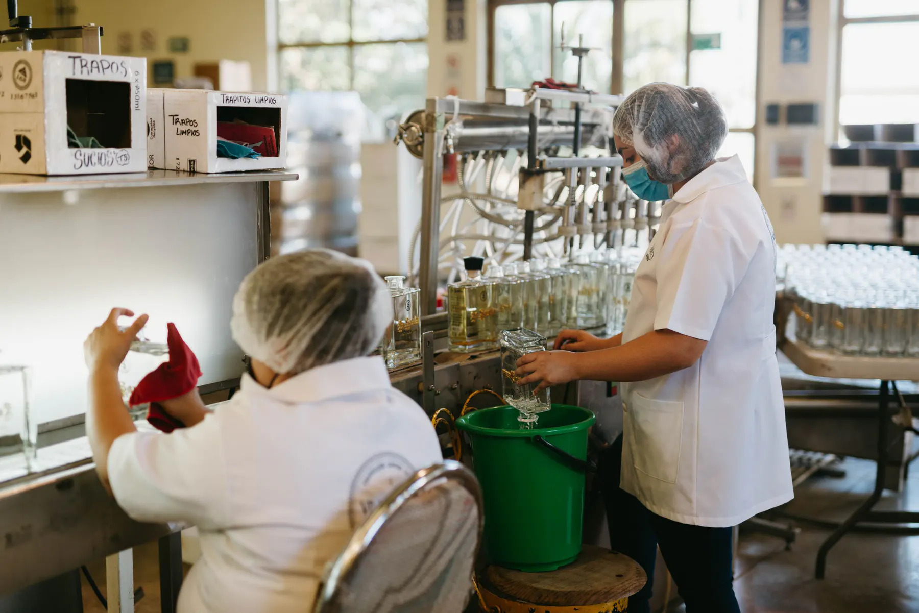 Operators working along a controlled bottle production line